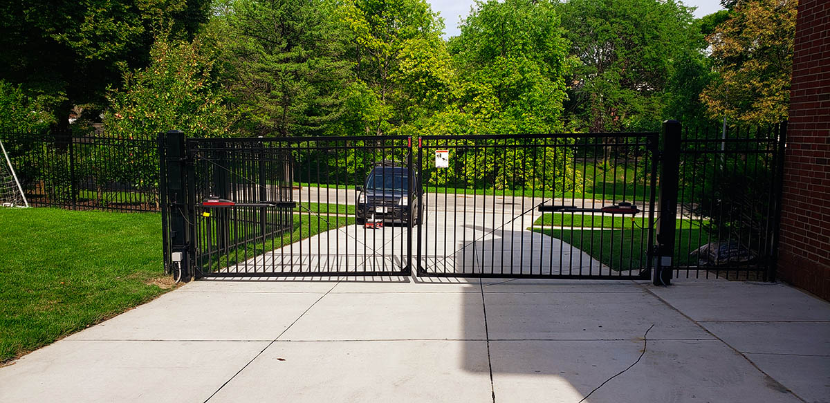 Interior view of a black, closed picket ornamental, double swing gate. Fargo fence company fence contractors North Dakota gates automation residential commercial